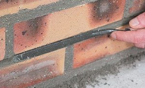 finition d'un mur en briques au fer à joints