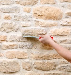 brosser les joints d'un mur en pierre